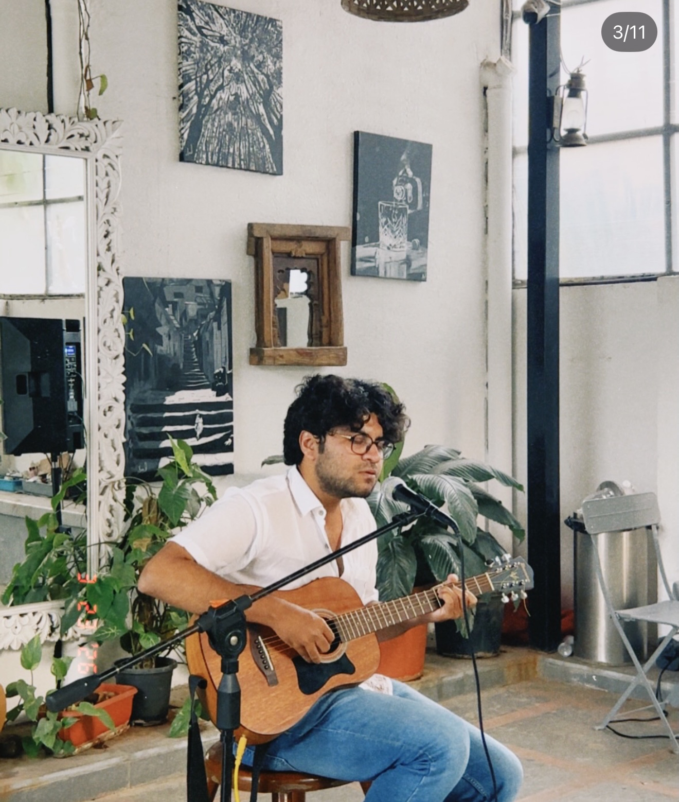 Musician in a white shirt playing acoustic guitar