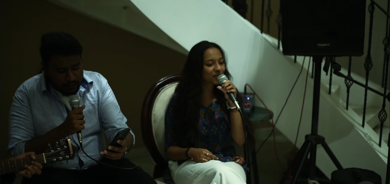 A guitarist and singer performing together on a staircase
