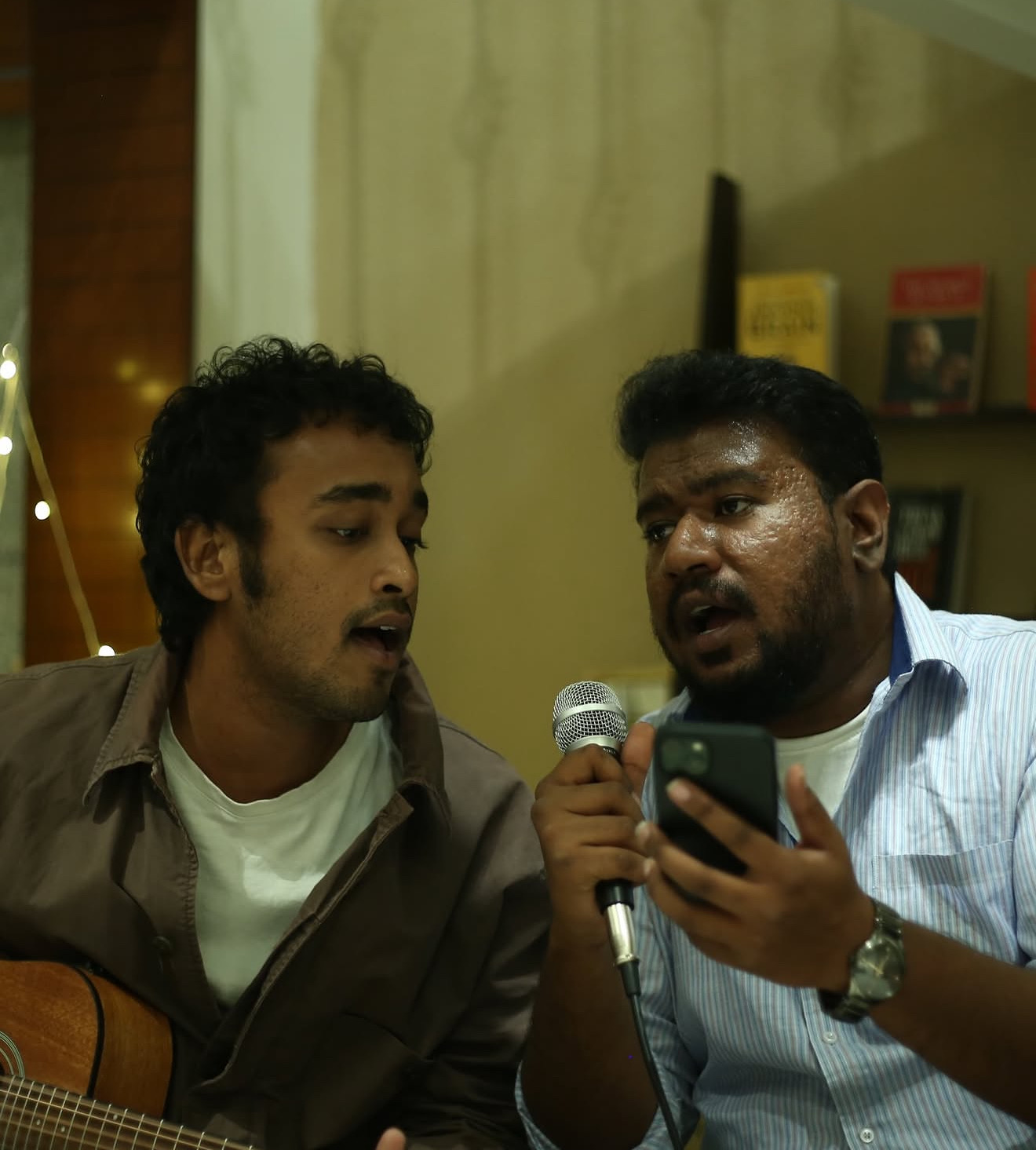 Two musicians harmonizing into one microphone